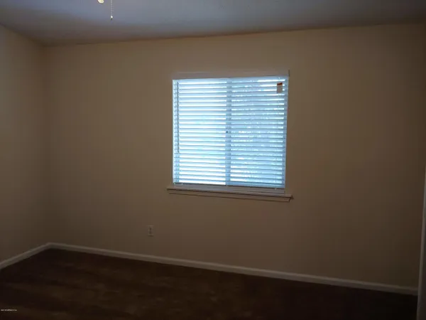 a view of a small space with wooden floor and a window