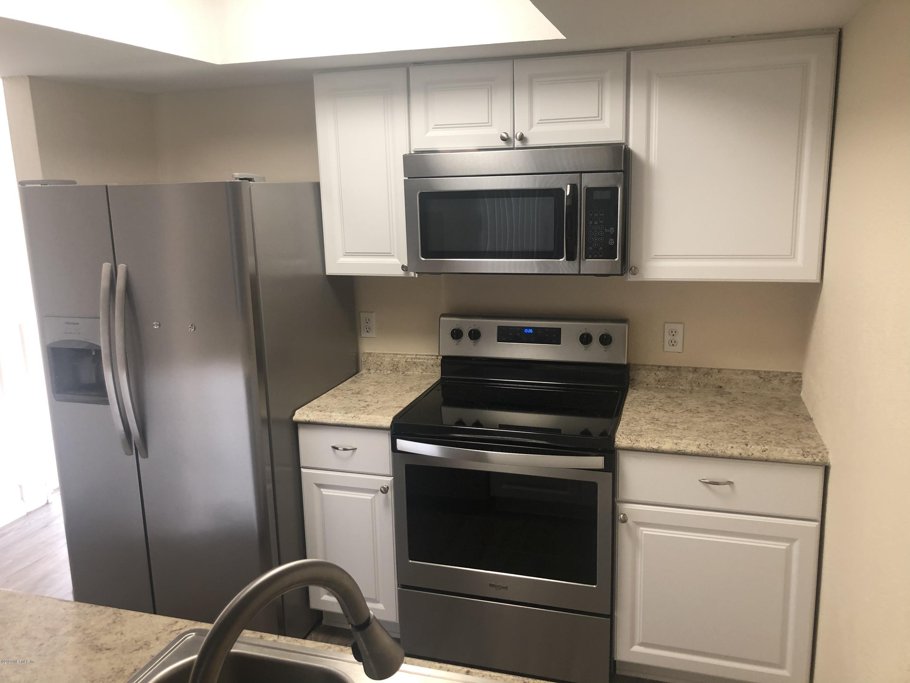 791 Assisi Lane, Unit 303 Jacksonville, FL 32233 - Photo 33 of 35 a kitchen with a stove microwave and refrigerator