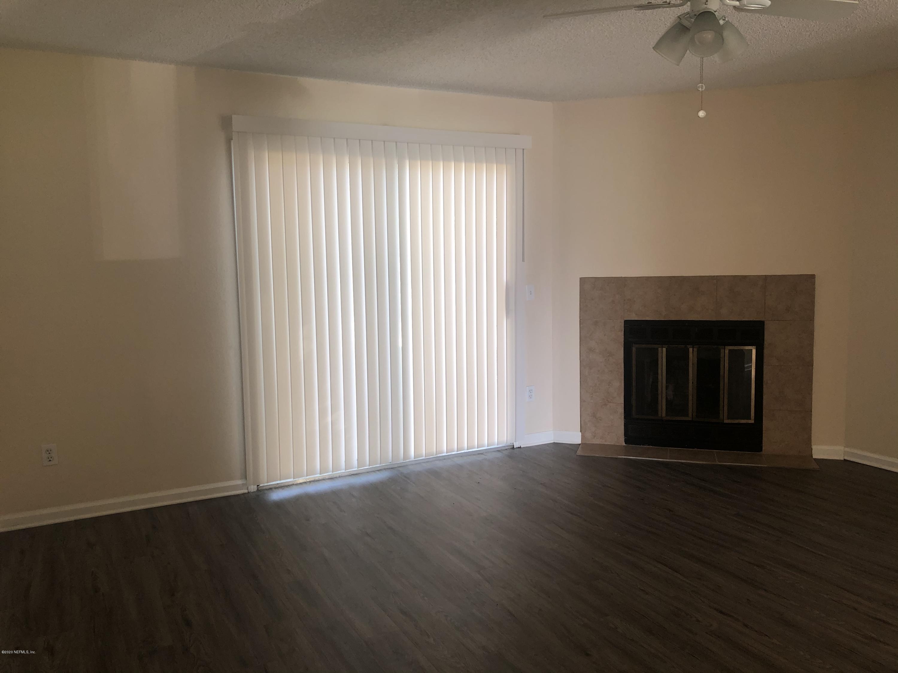 791 Assisi Lane, Unit 303 Jacksonville, FL 32233 - Photo 35 of 35 an empty room with wooden floor fireplace and windows