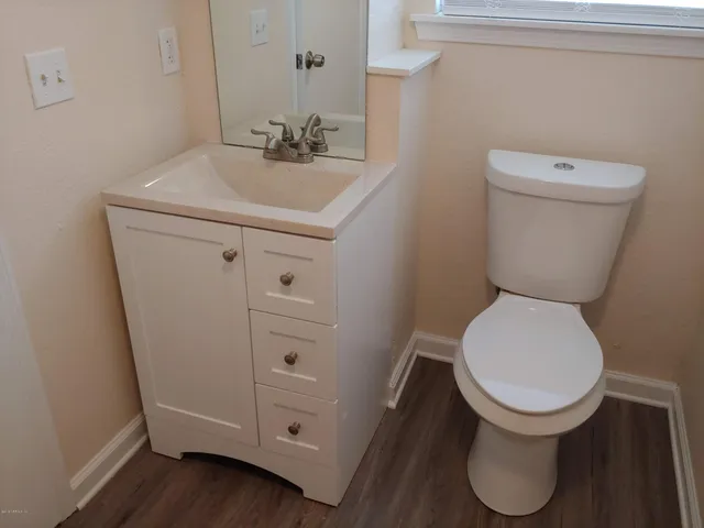 a bathroom with a toilet sink and mirror