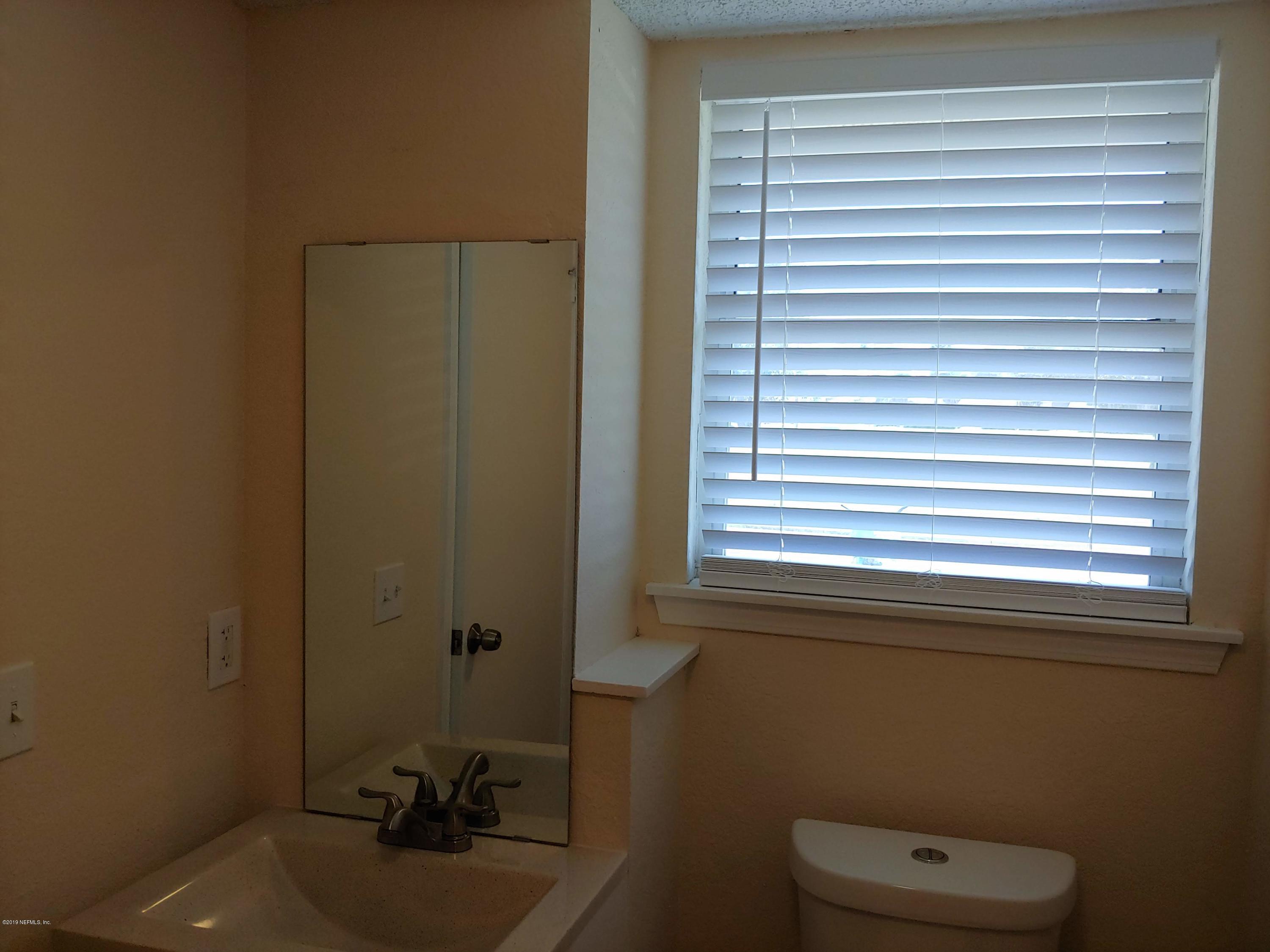 791 Assisi Lane, Unit 303 Jacksonville, FL 32233 - Photo 9 of 35 a bathroom with a sink a toilet and a window