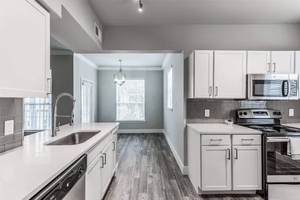 a kitchen with stainless steel appliances a refrigerator a stove a sink and a window
