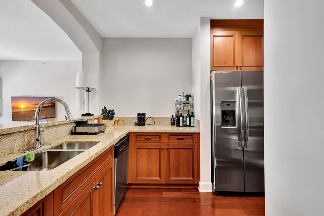 a kitchen with stainless steel appliances granite countertop a sink and a refrigerator