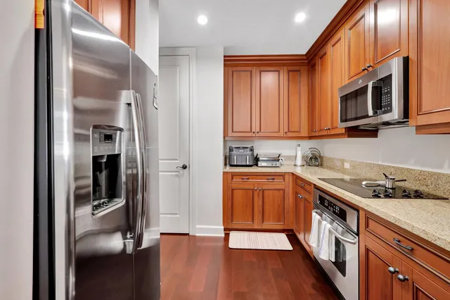a kitchen with stainless steel appliances granite countertop a refrigerator and a stove top oven
