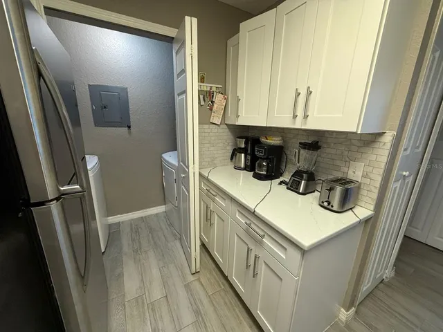 a kitchen with a sink a refrigerator and cabinets