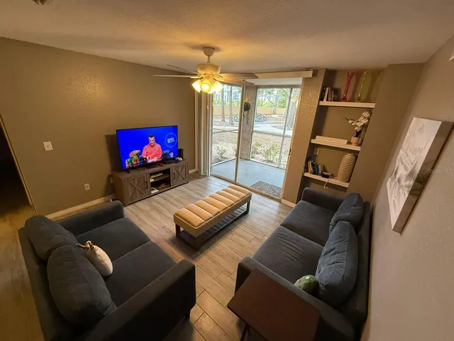 a living room with furniture a flat screen tv and a fireplace