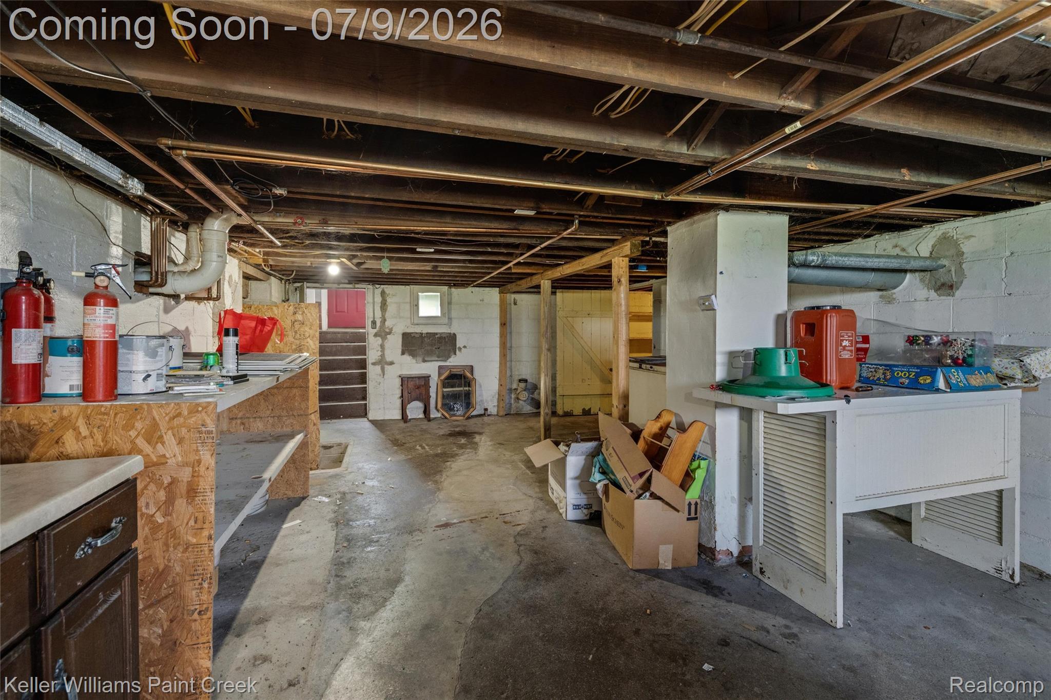 28780 School Section Road Richmond, MI 48062 - Photo 31 of 50 Unfinished basement featuring exposed wood ceiling joists, concrete flooring, and a red interior door at the far end