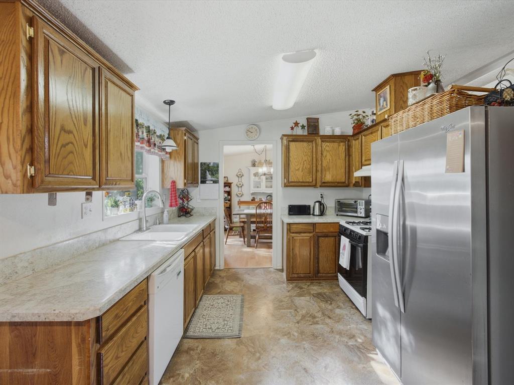 3275 Finis Road Graham, TX 76450 - Photo 9 of 36 a kitchen with stainless steel appliances granite countertop a sink stove and refrigerator