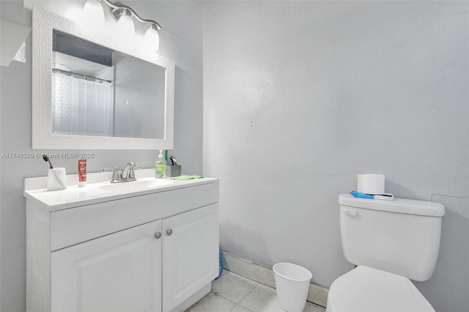 1945 West 72nd Street Hialeah, FL 33014 - Photo 15 of 24 a bathroom with a toilet sink vanity and mirror