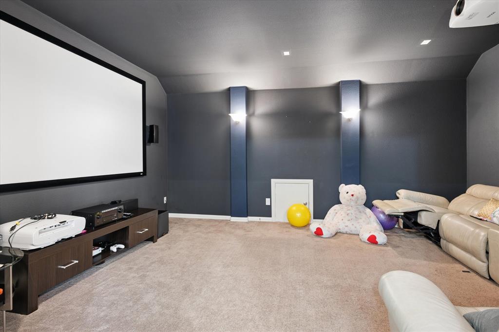 8268 Kara Creek Road Frisco, TX 75036 - Photo 20 of 31 Media room featuring a large projection screen, dark accent walls, recessed lighting, carpeted flooring, and a built-in media console
