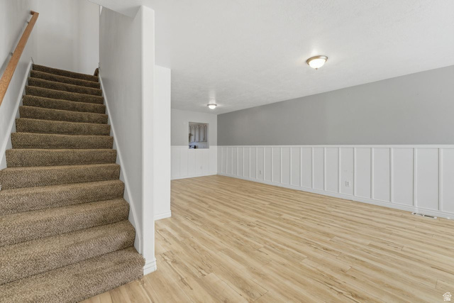 977 East 100 South Payson, UT 84651 - Photo 9 of 19 Staircase with a wainscoted wall, wood finished floors, and a decorative wall