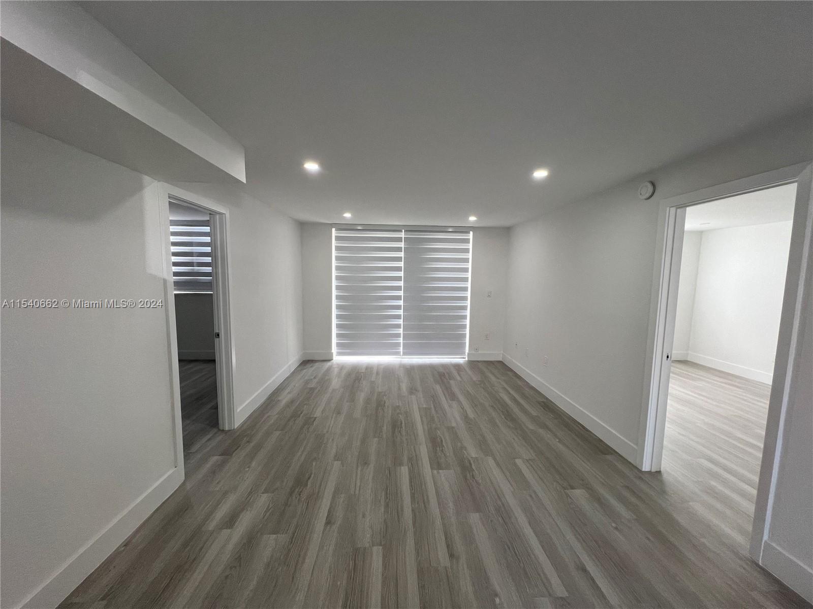 14155 Southwest 87th Street, Unit E108 Miami, FL 33183 - Photo 2 of 9 wooden floor in an empty room with a window
