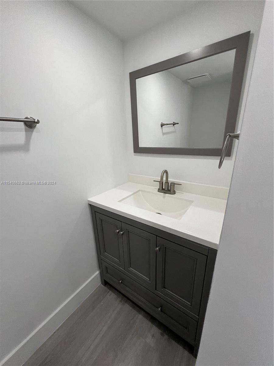 14155 Southwest 87th Street, Unit E108 Miami, FL 33183 - Photo 7 of 9 a bathroom with a sink vanity and mirror
