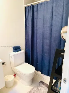 a white toilet sitting next to a bathroom sink and vanity