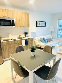 a view of kitchen with stainless steel appliances dining table and chairs