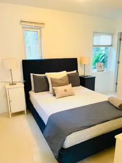 a bedroom with a bed and a potted plant