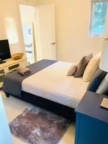 a bedroom with bed and mirror