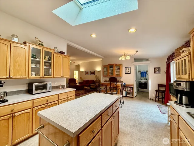 a large white kitchen with a large window and furniture