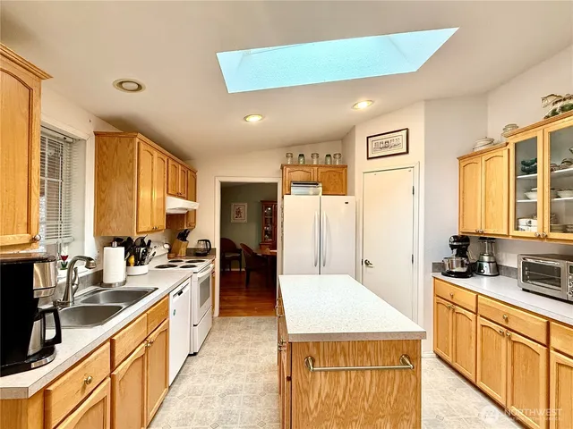 a large kitchen with kitchen island a sink stainless steel appliances and cabinets
