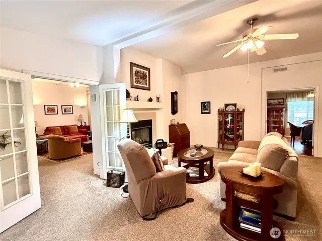 a living room with furniture a fireplace and a chandelier