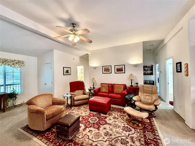a living room with furniture a ceiling fan and a window