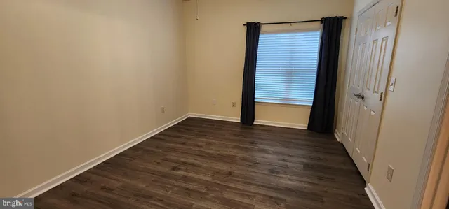 a view of a small space with wooden floor and a window