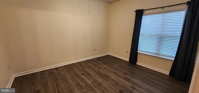 a view of a small space with wooden floor and a window