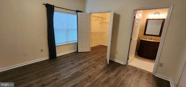 an empty room with wooden floor and mirror