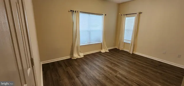 an empty room with wooden floor and closet