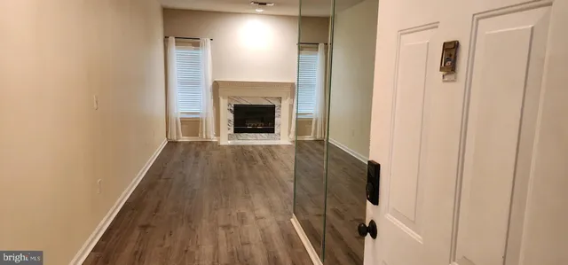 a view of a livingroom with wooden floor and a fireplace