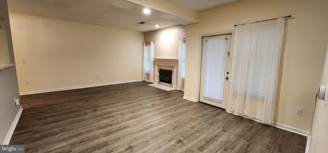 a view of a livingroom with wooden floor and a ceiling fan