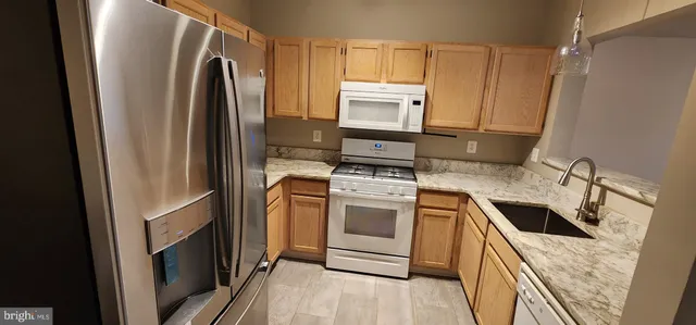 a kitchen with a refrigerator sink and cabinets