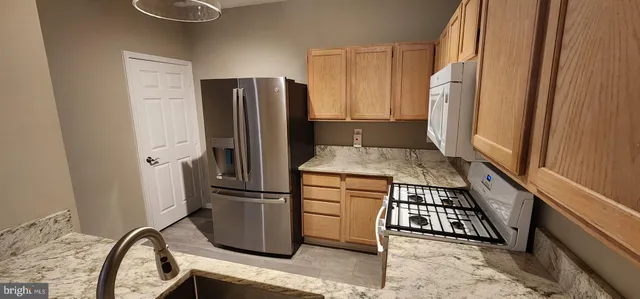a kitchen with stainless steel appliances granite countertop a refrigerator and a stove