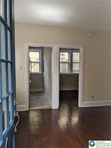 an empty room with wooden floor and a bathroom