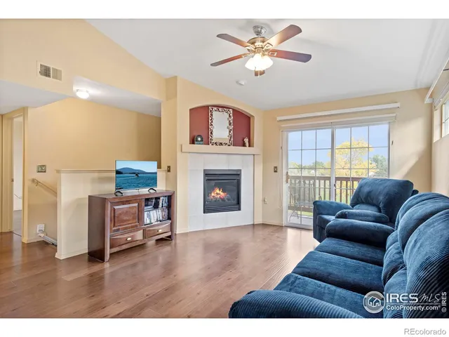 a living room with furniture a fireplace and a large window