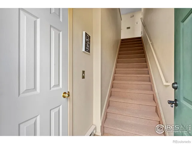 a view of a hallway with wooden floor and stairs