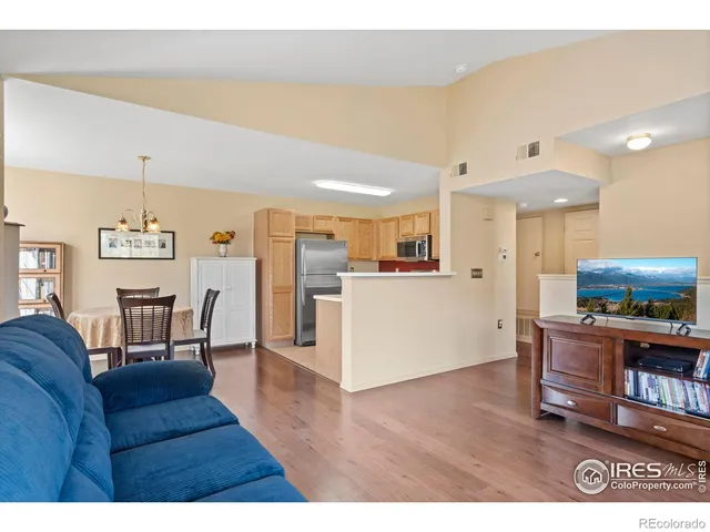 a living room with furniture and a dining table with kitchen view