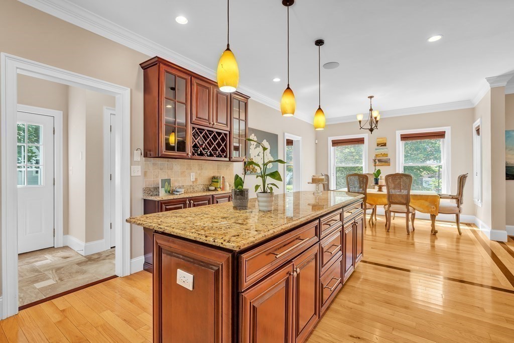 138 Webster Street Needham, MA 02494 - Photo 6 of 29 a kitchen with kitchen island granite countertop a stove a sink a dining table and chairs with wooden floor