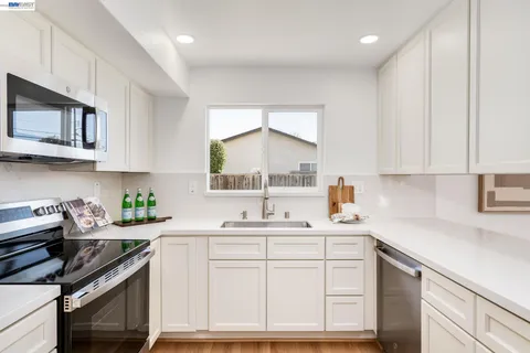 a kitchen with stainless steel appliances a sink stove and cabinets
