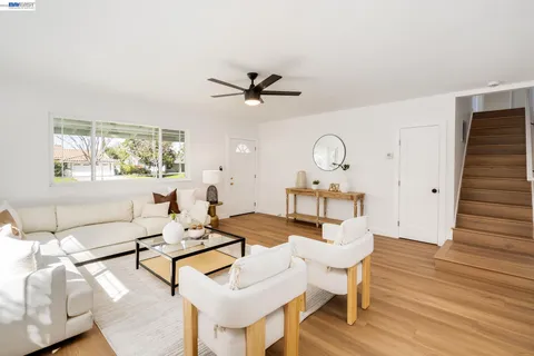 a living room with furniture a chandelier and a window
