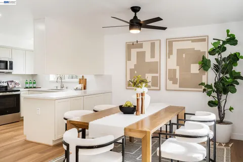 a dining room with furniture potted plants and wooden floor