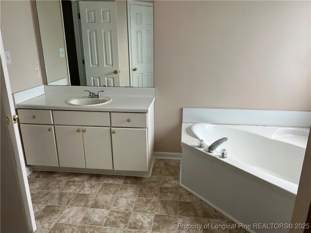 a view of a yard with plants and large trees