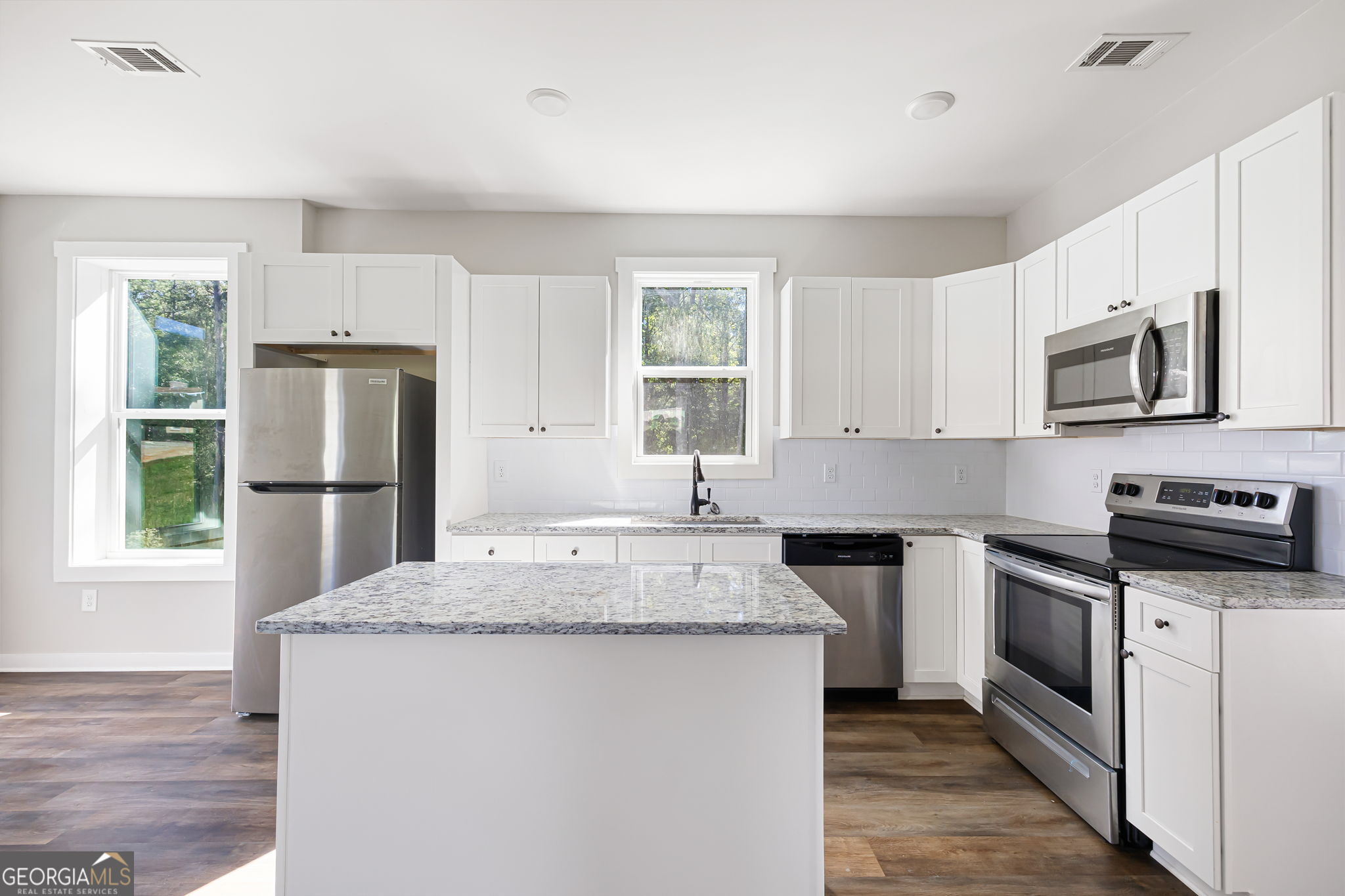 205 Pinecrest Road Cedartown, GA 30125 - Photo 12 of 27 a kitchen with stainless steel appliances granite countertop a stove a sink dishwasher a refrigerator and a microwave oven with wooden floor