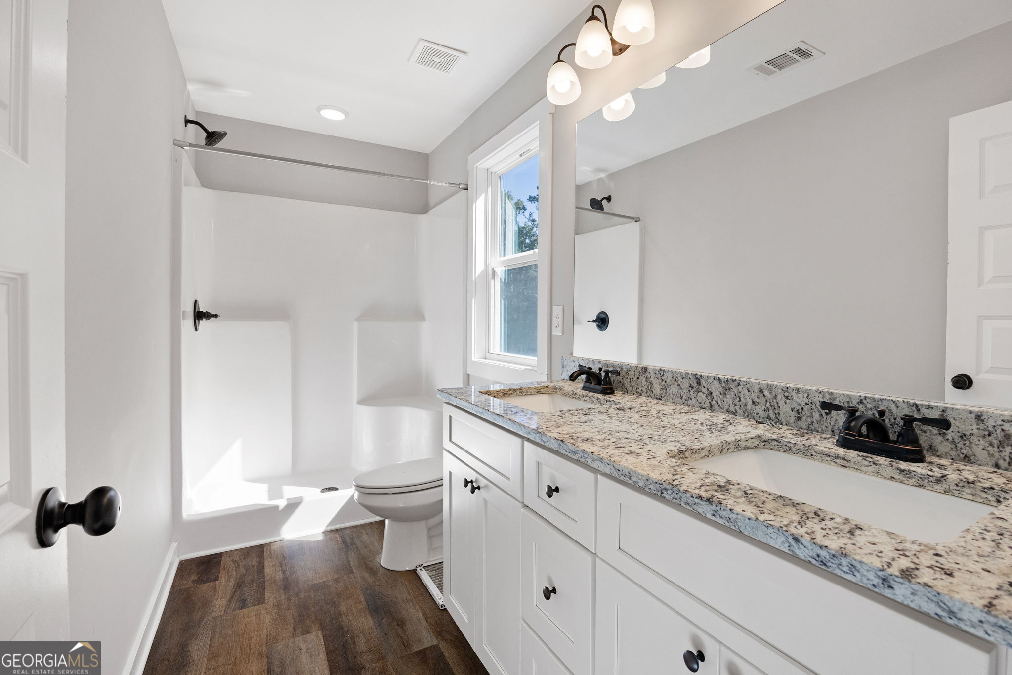 205 Pinecrest Road Cedartown, GA 30125 - Photo 20 of 27 a bathroom with a granite countertop sink a toilet a mirror and shower