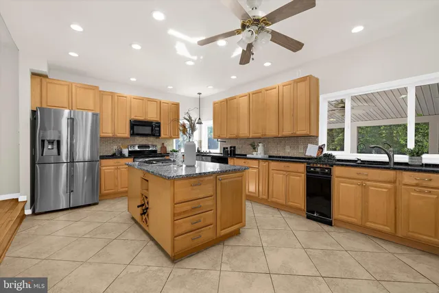 a large kitchen with kitchen island a counter top space appliances and cabinets