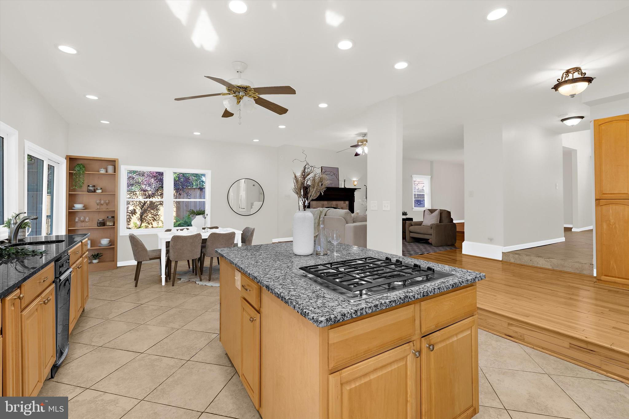 619 Riverside Drive Pasadena, MD 21122 - Photo 17 of 84 a kitchen with granite countertop a stove a sink a dining table and chairs