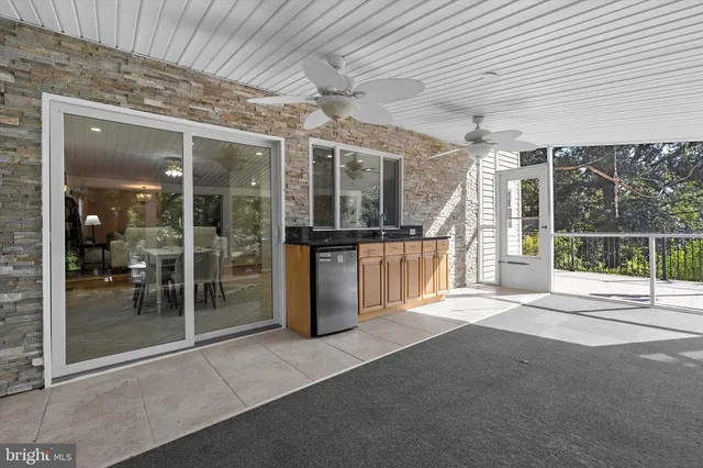 an empty room with windows and chandelier fan