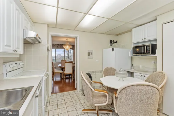 a kitchen with stainless steel appliances granite countertop a sink a microwave refrigerator and chairs