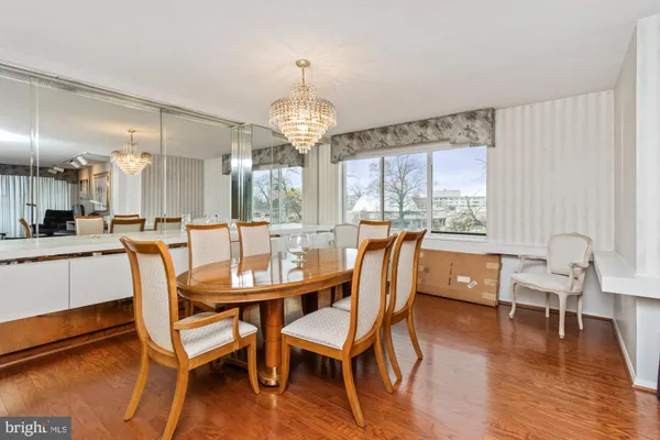 a dining room with furniture a chandelier and wooden floor