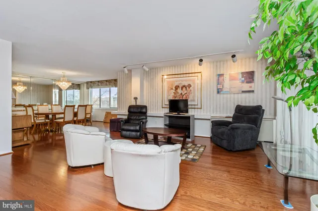 a living room with furniture a large window and wooden floor